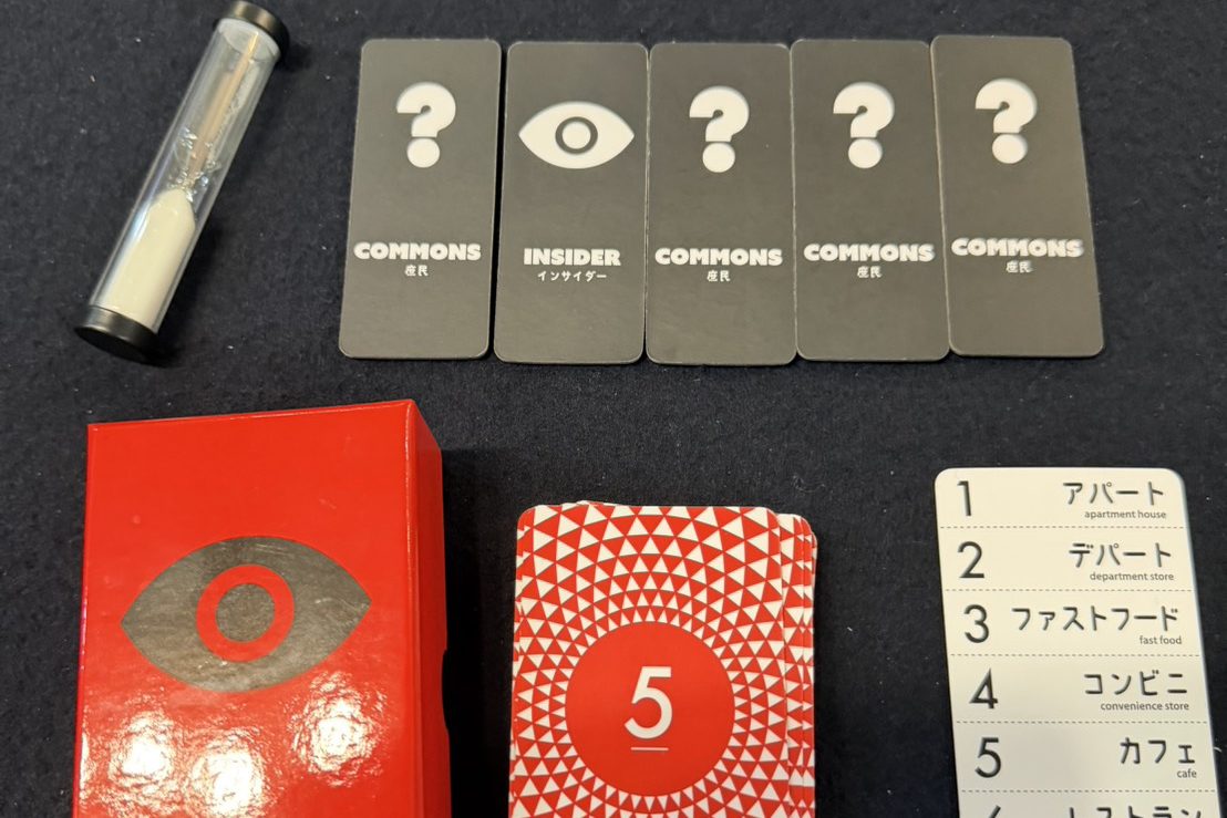 インサイダーゲームの一式。砂時計、COMMONS（庶民）とINSIDER（インサイダー）の役割カード、お題カード、赤い箱